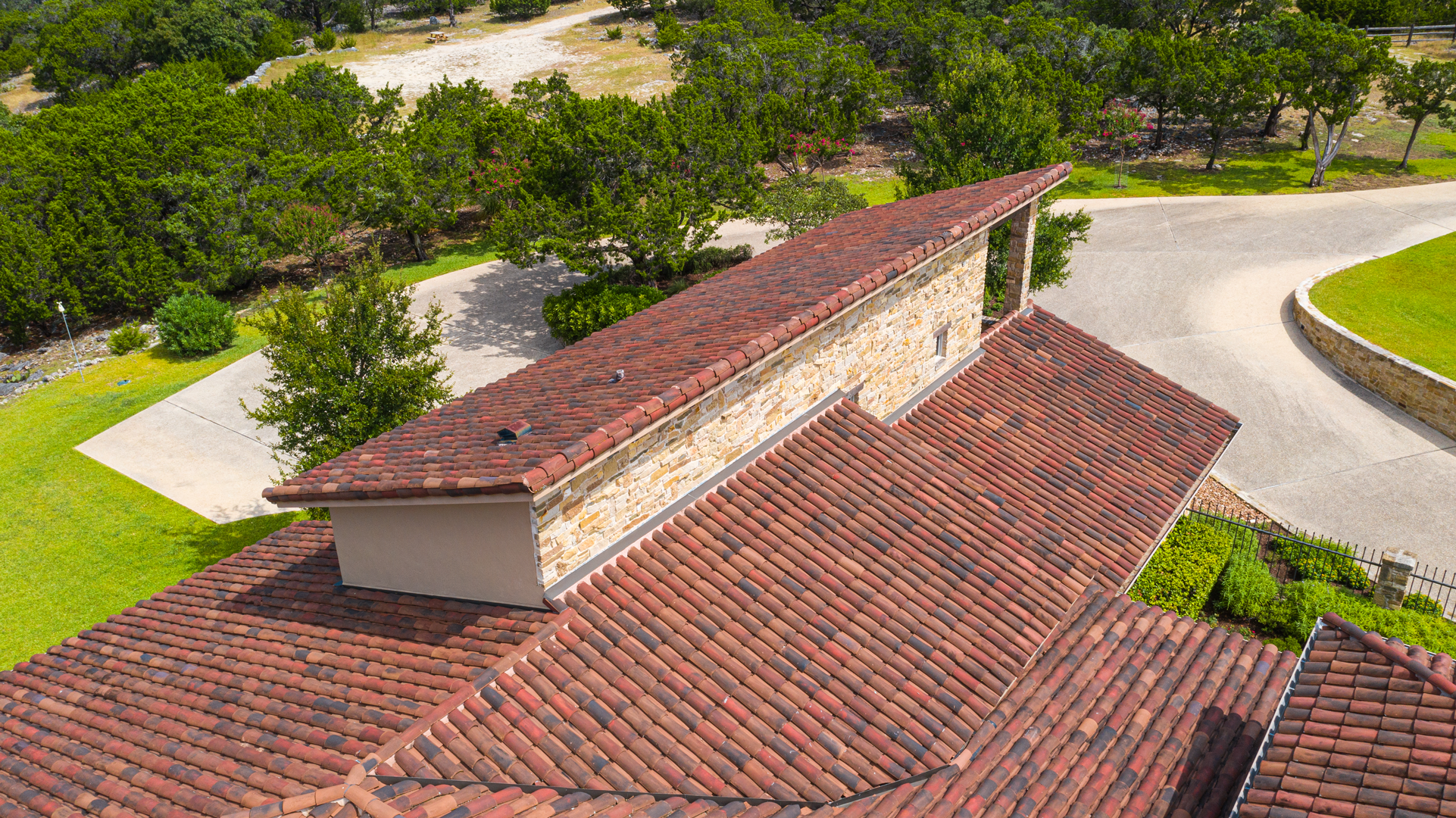 Top view of the handmade clay tile roof on a residential property in Ingram, Texas, installed by Schulte Roofing.