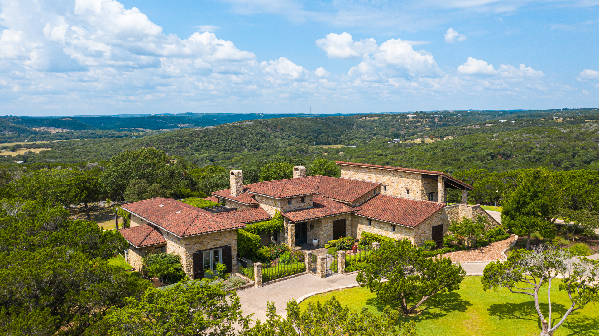 Aerial view of a residential property with a handmade clay tile roof in Ingram, Texas, installed by Schulte Roofing.