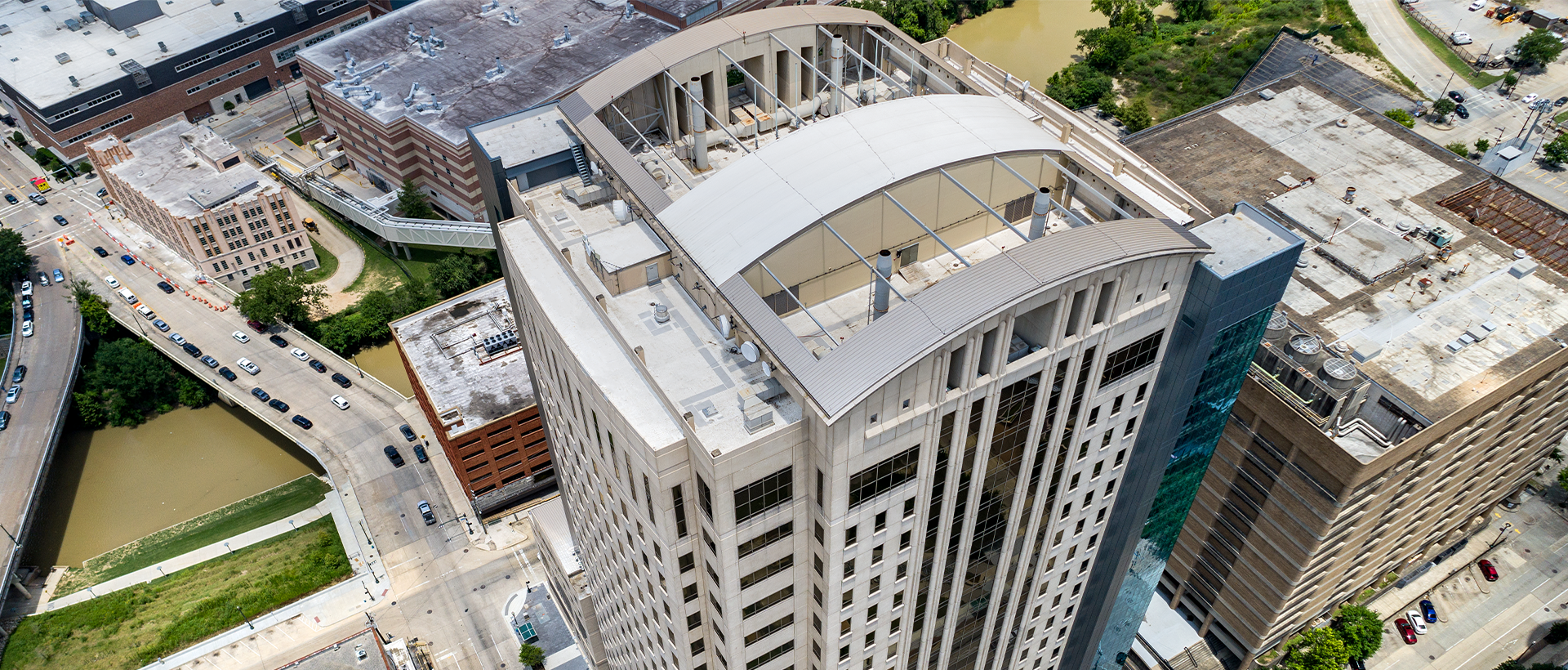 The Texas Department of Public Safety's Criminal Justice Center membrane roofing by Schulte Roofing with a view of the roof and neighboring buildings.