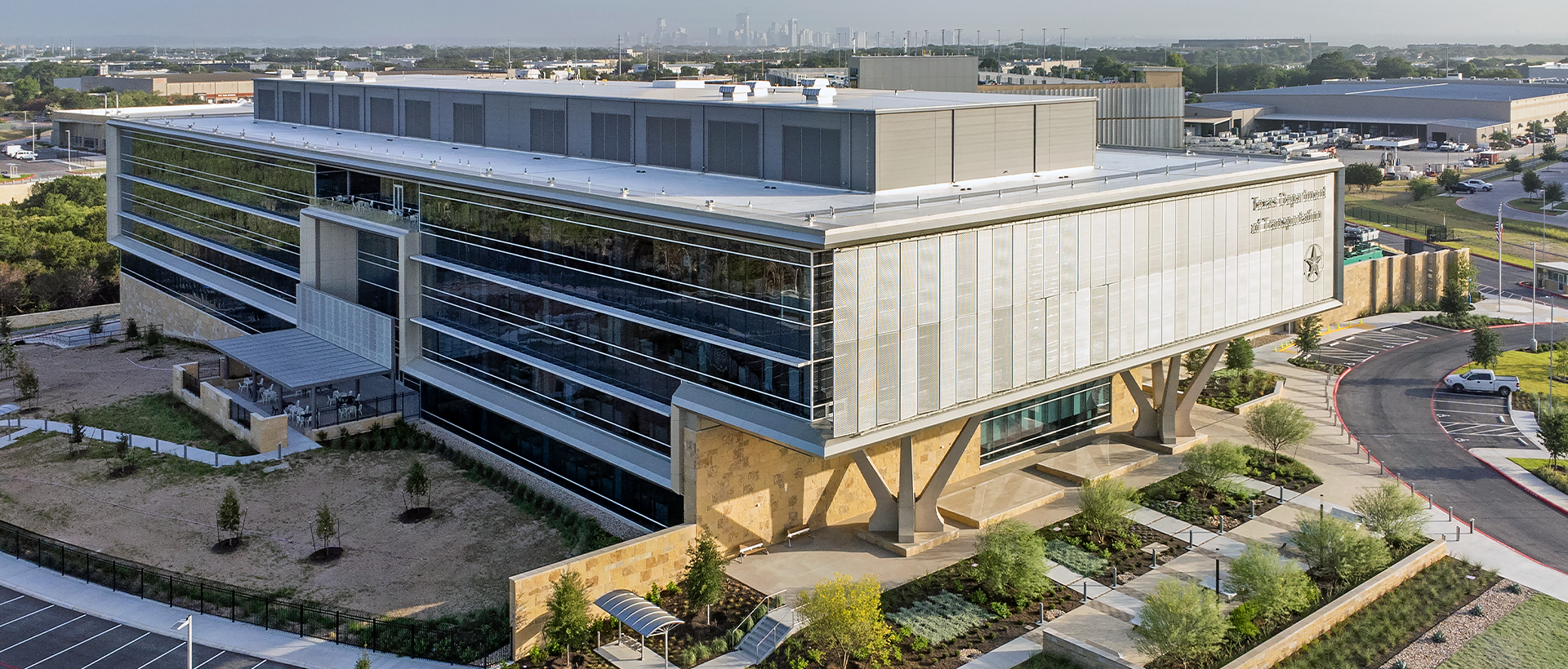 Texas Department of Public Safety's finished commercial flat roof by Schulte Roofing and building facade with view of the entire building and Austin skyline.